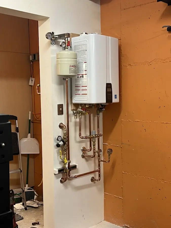 Plumbing technician inspecting water heater connections in Towamensing